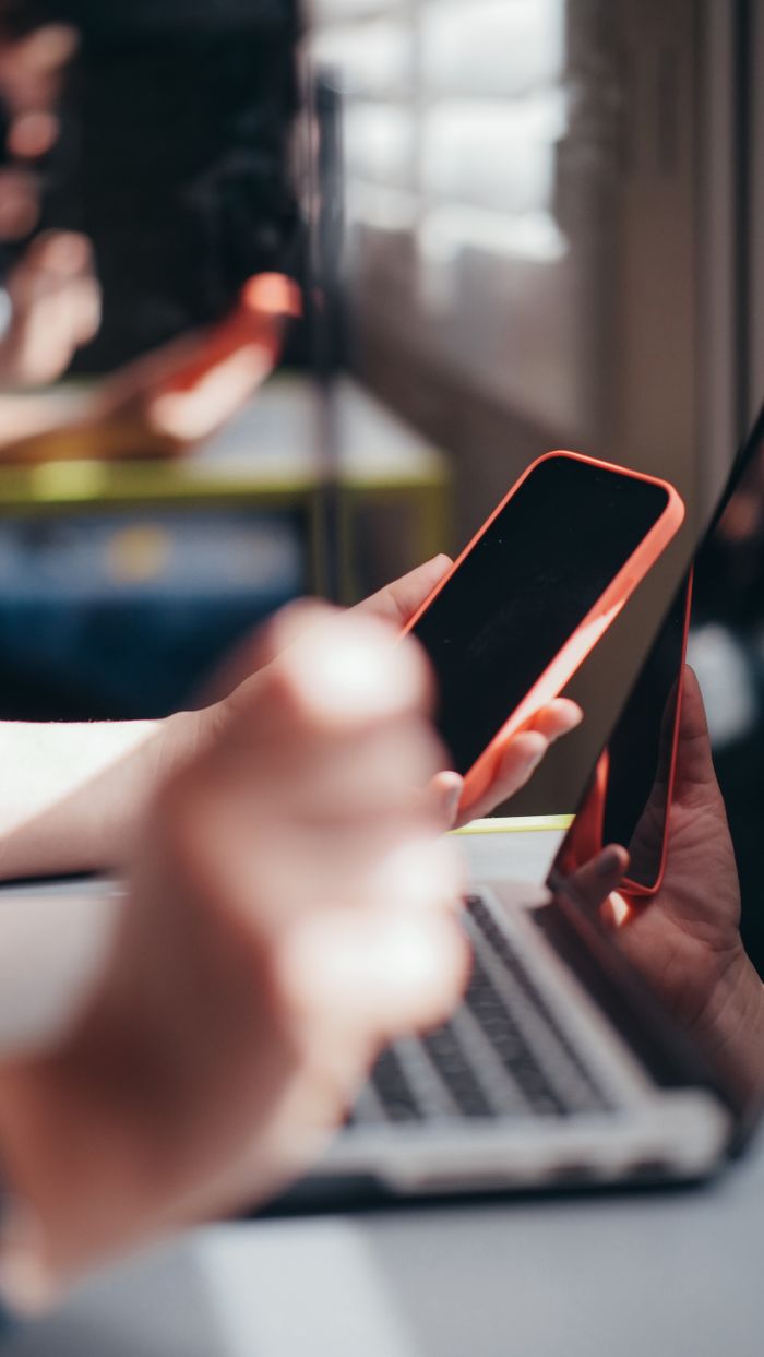 Crafting Captivating Headlines: Your awesome post title goes here Hands holding smartphone near laptop, showcasing multitasking and technology use.